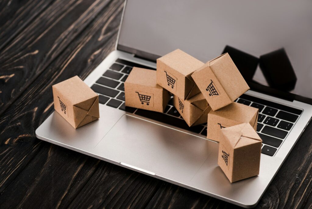 small carton boxes on laptop with blank screen, e-commerce concept